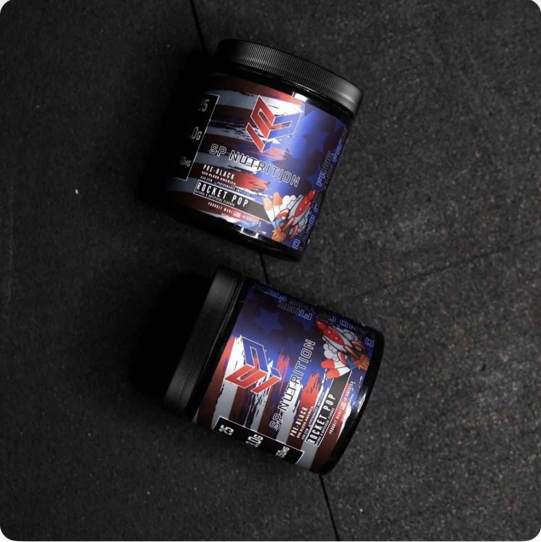 Two SP Nutrition Rocket Pop supplement tubs on a dark surface